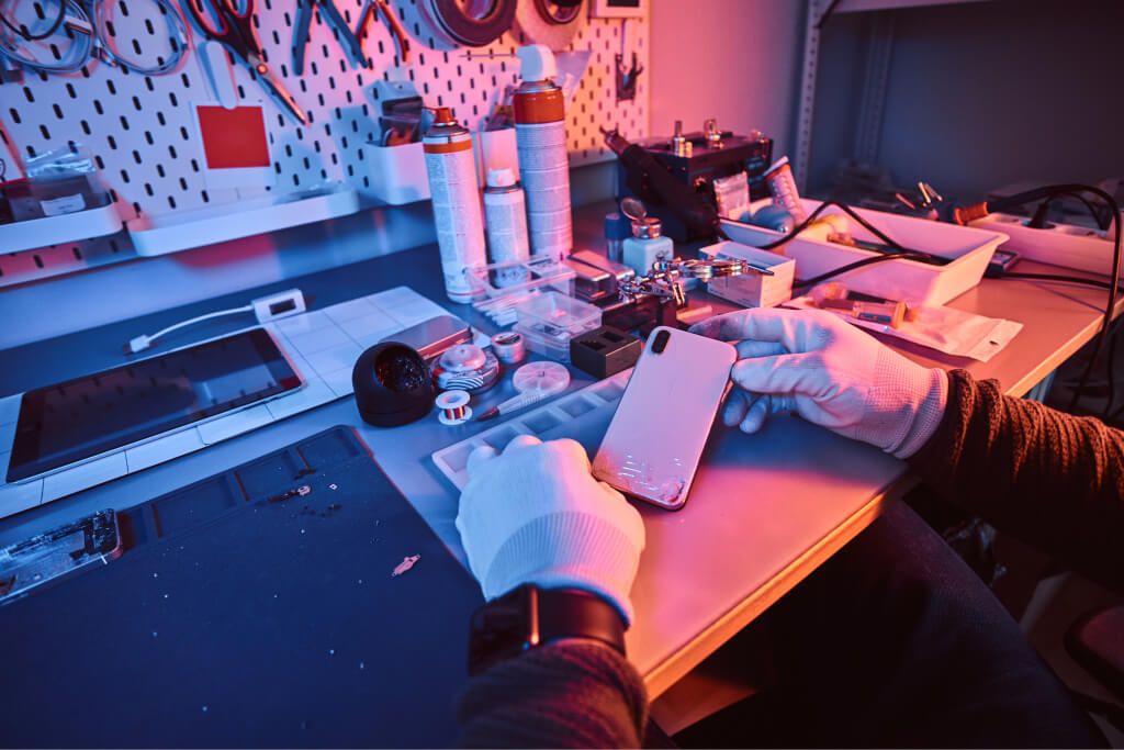 electronic technician holds a modern smartphone wi GJBH8NZ